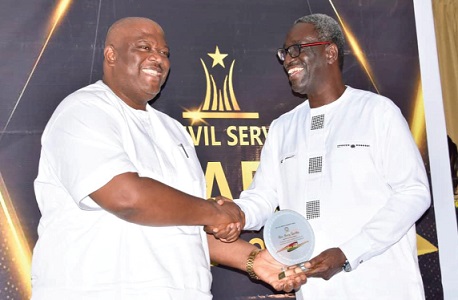 Nana Kwasi Agyekum (right), Head of the Civil Service, Ghana, presenting the award to Henry Quartey, Greater Accra Regional Minister